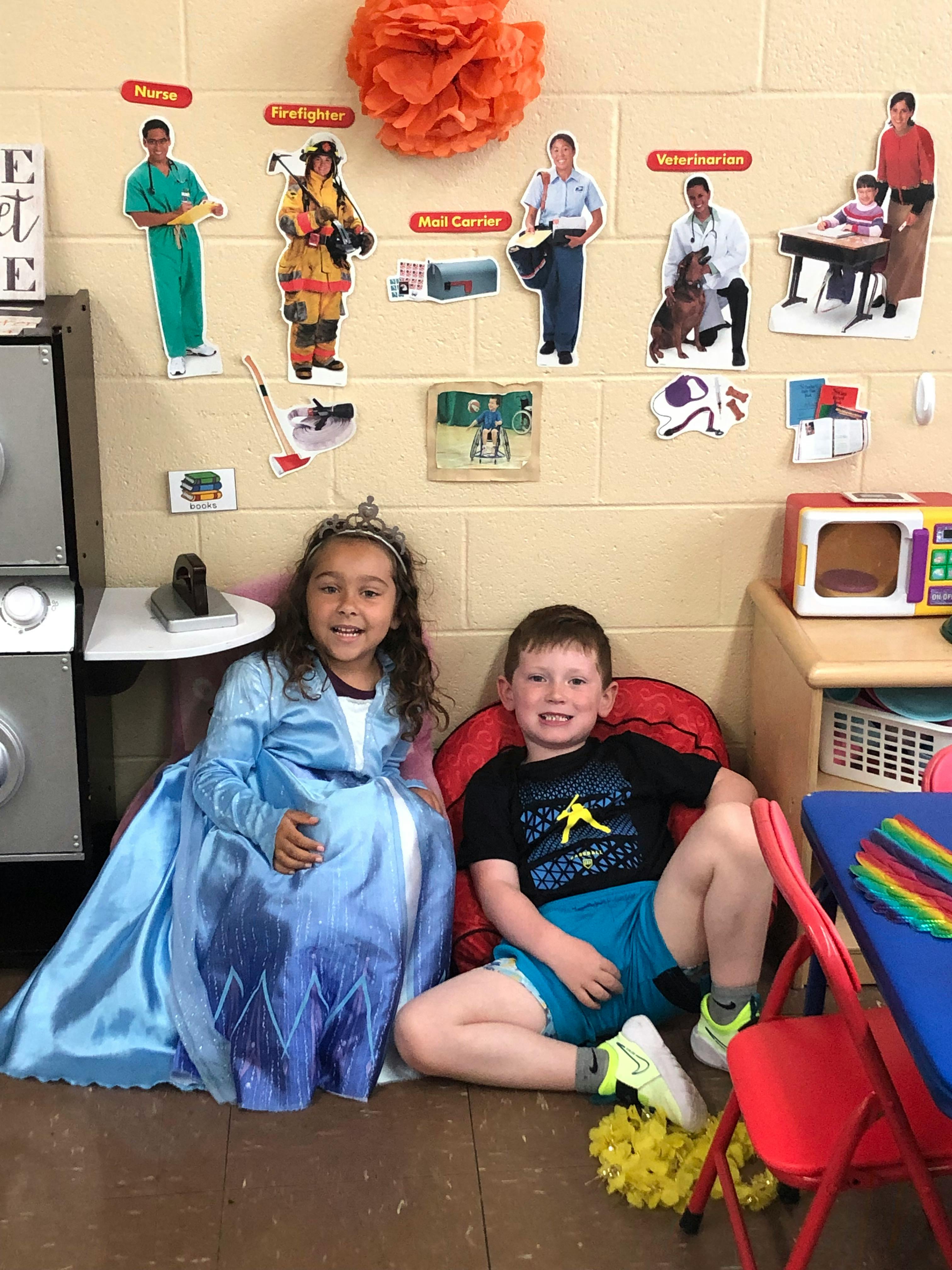 Child in blue dress and child in t-shirt sitting on floor