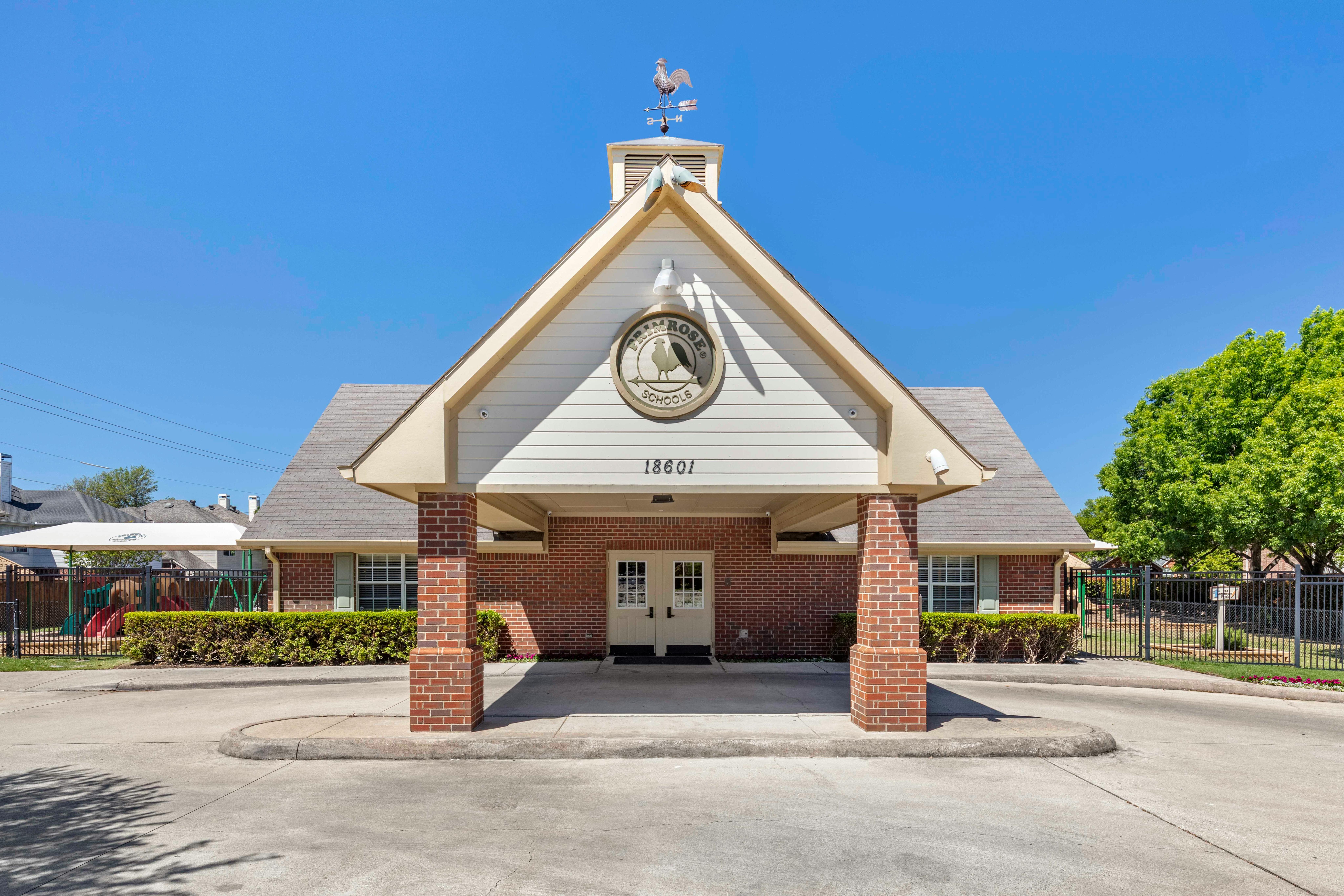 Primrose School building with a rooster weathervane and 18601 address