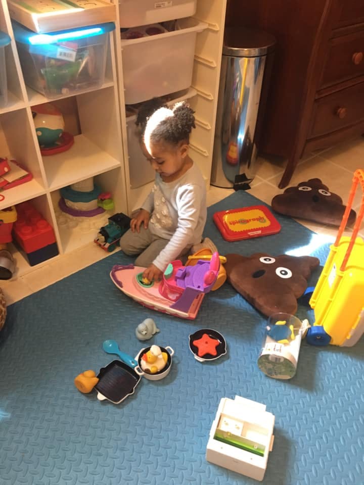 Child playing with toys on a blue mat