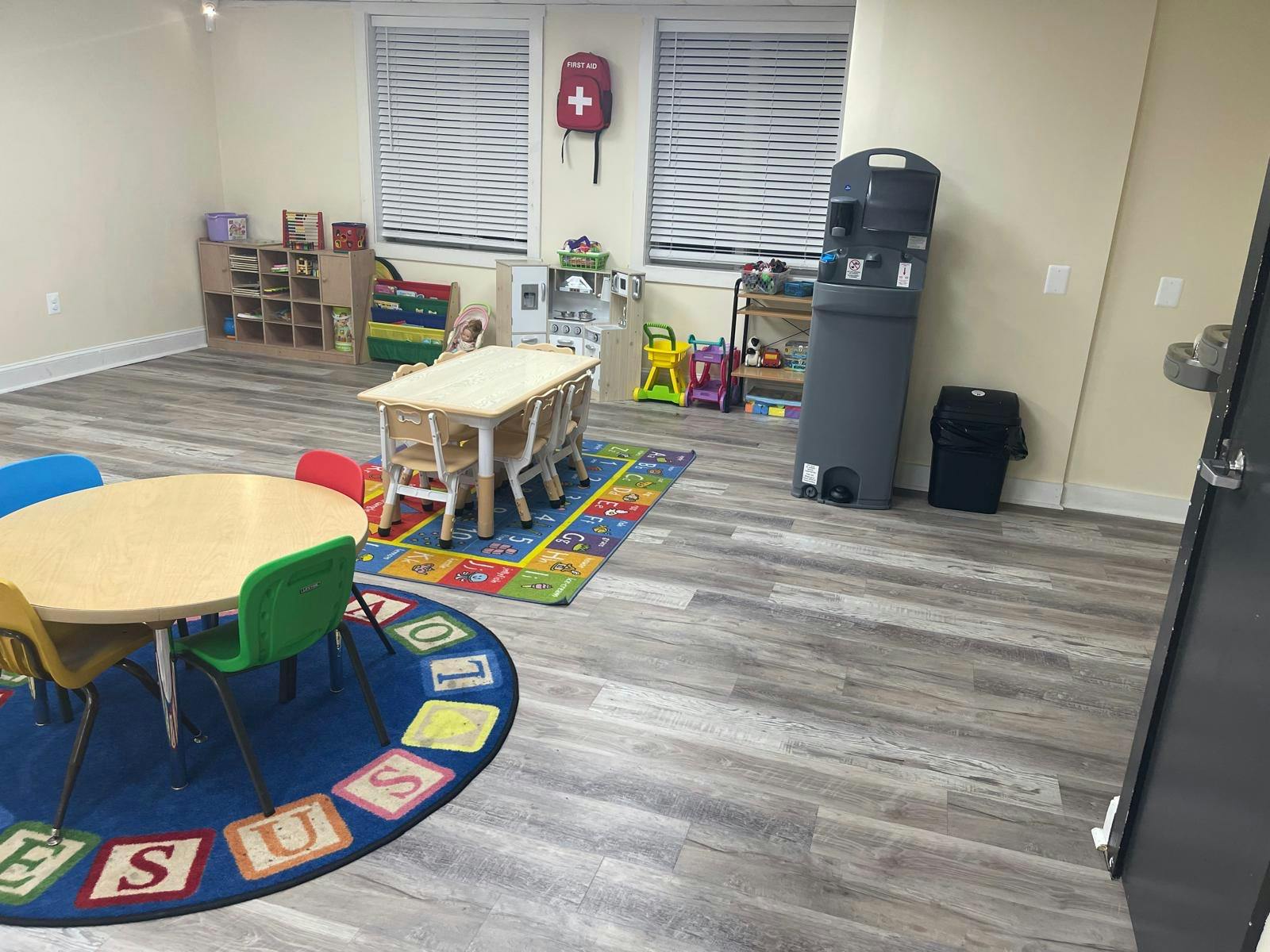 Classroom with small tables and chairs on colorful rugs