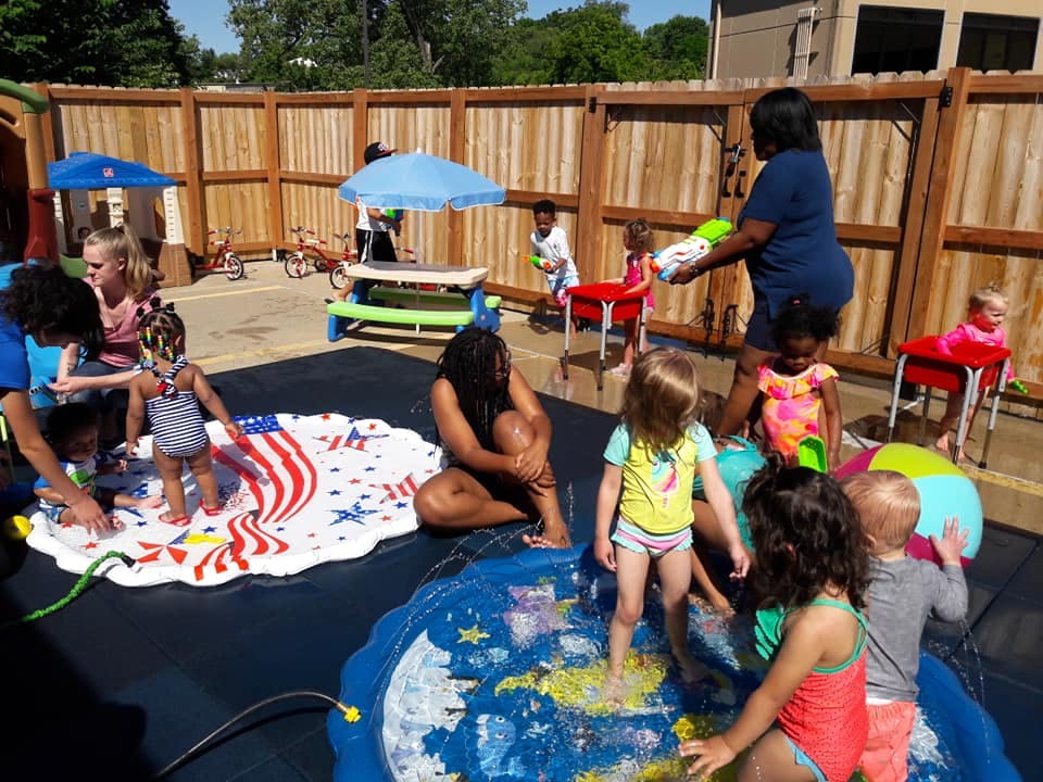 Adults and children playing in water on splash pads