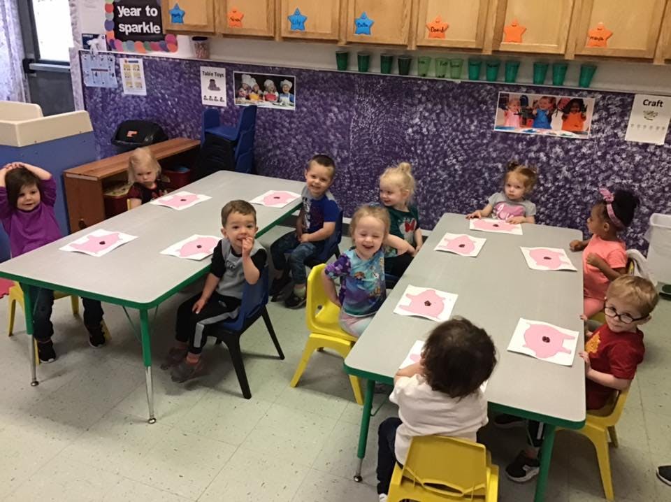 Children sitting at tables in a classroom