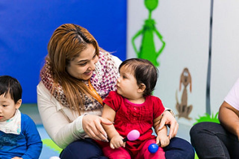 Person holding a child with another child nearby
