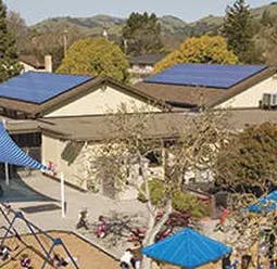 Building with solar panels and a playground