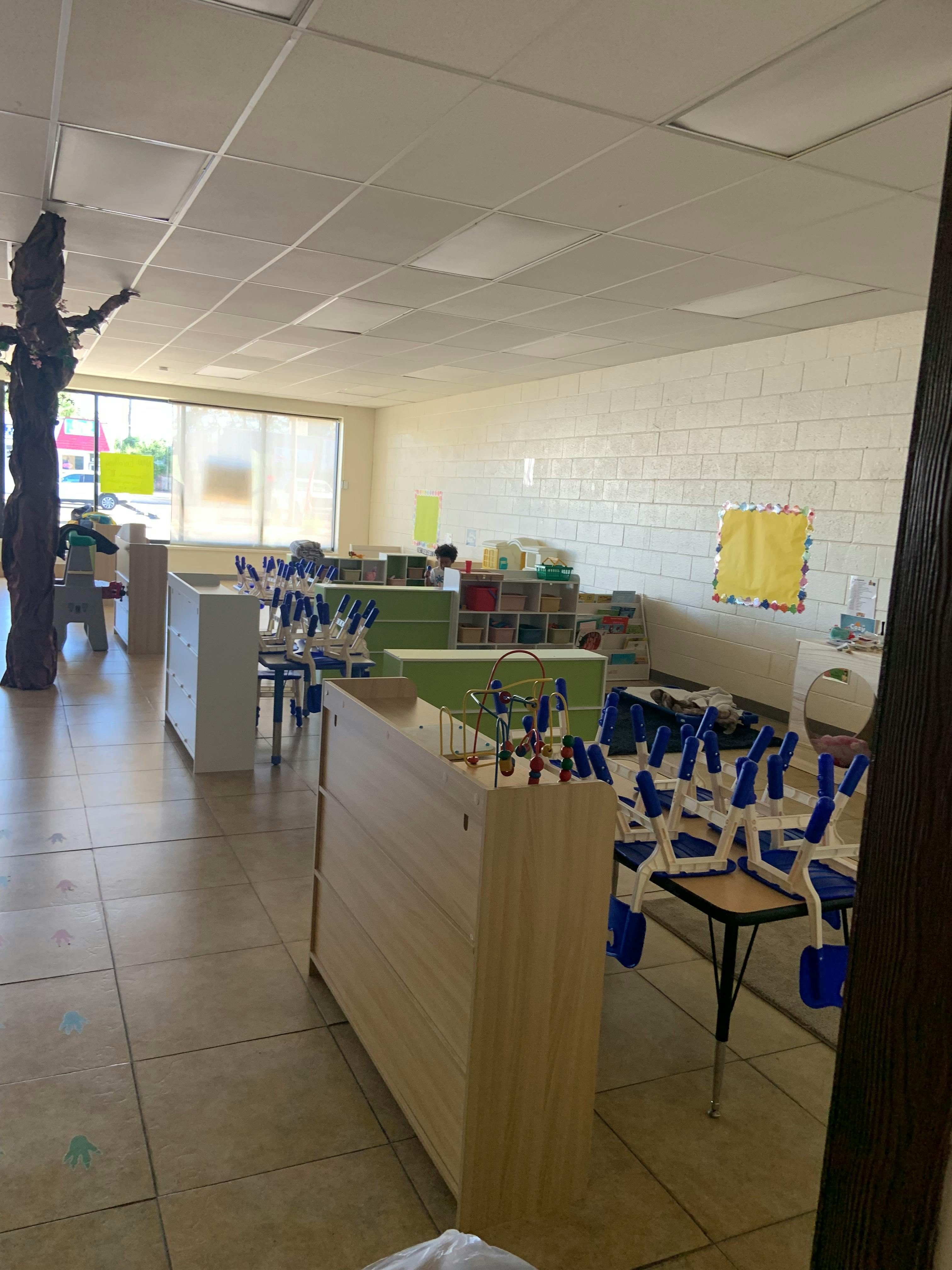 Classroom with tables and chairs, storage units, and a large window