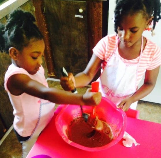 Two children mixing ingredients in a bowl
