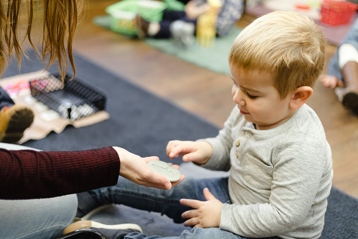 Person handing a small object to a child