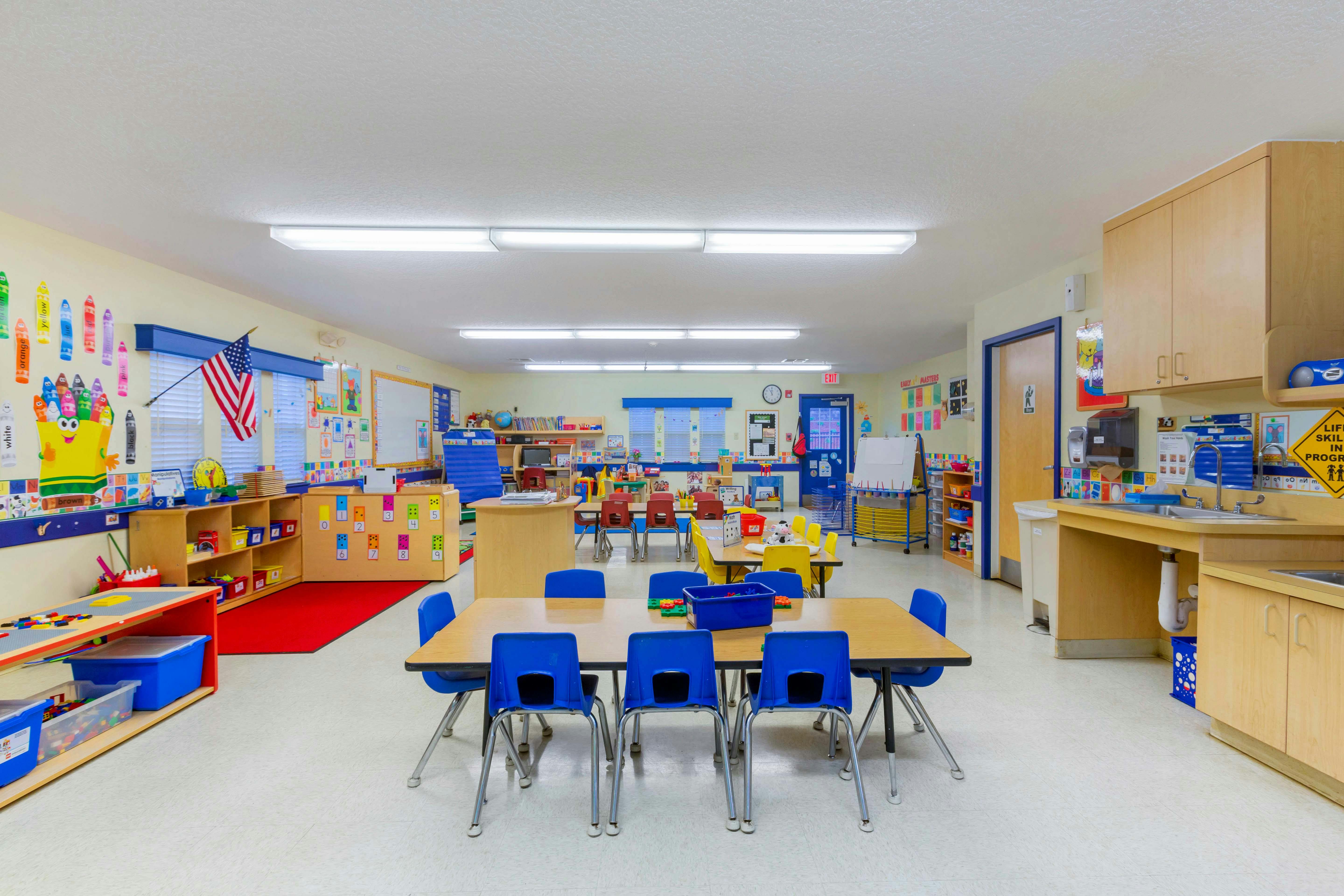 Classroom with small tables, colorful chairs, and learning materials