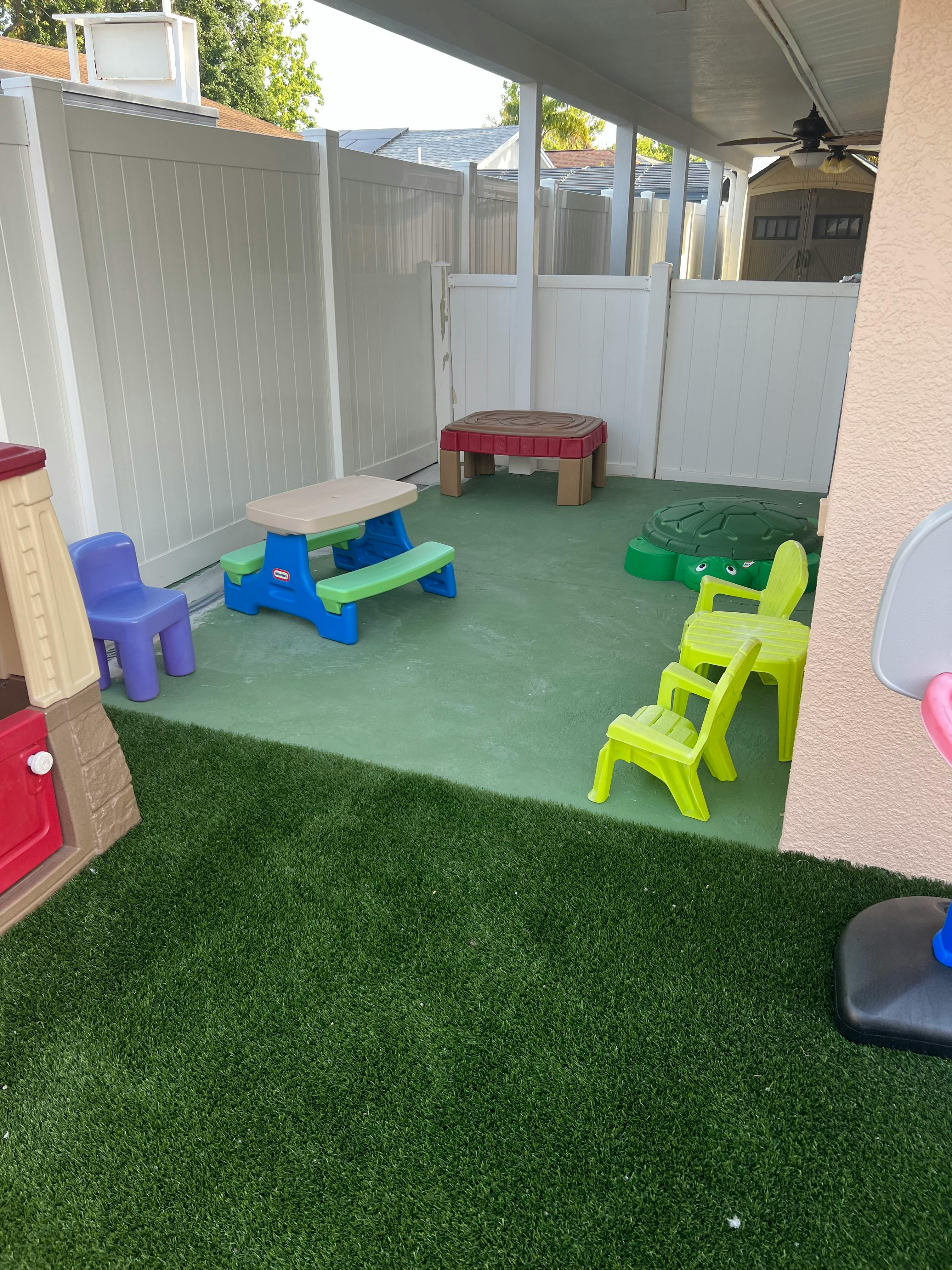 Outdoor play area with artificial turf and plastic children's furniture
