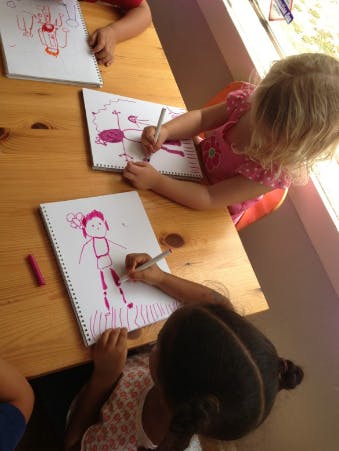 Children drawing with markers at a table