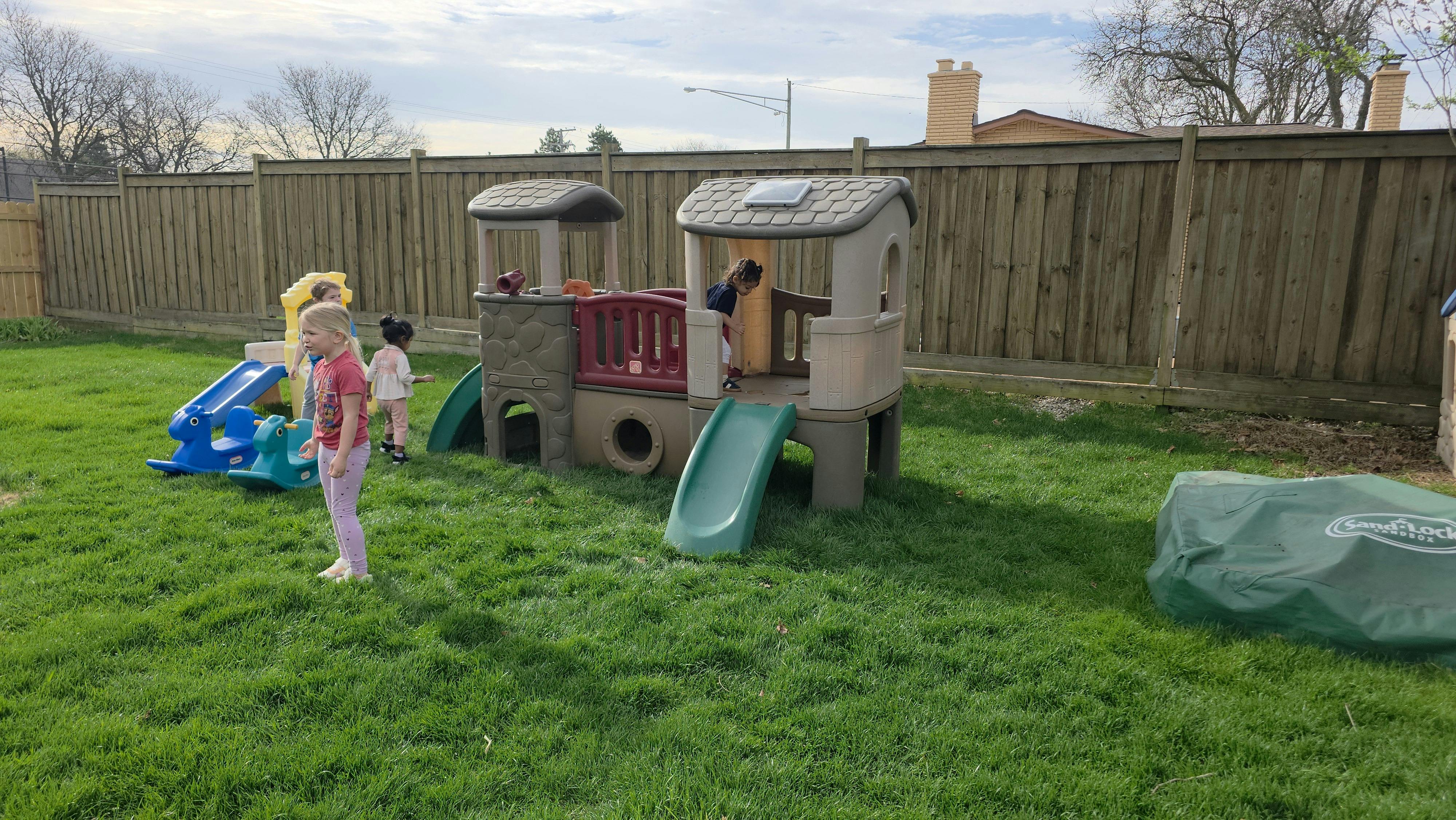 Children playing on a backyard playground structure