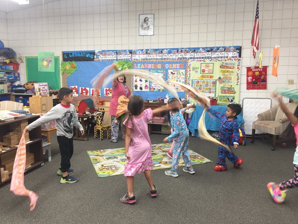 Children playing with scarves in a classroom