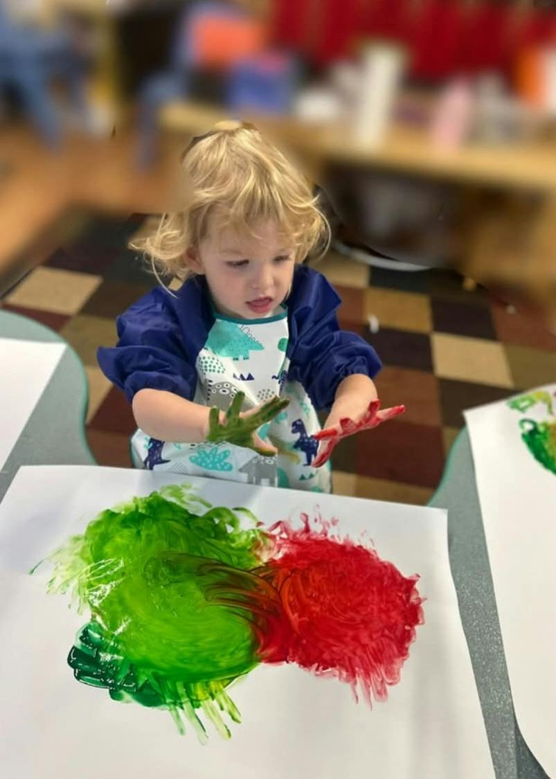Child painting with hands on paper
