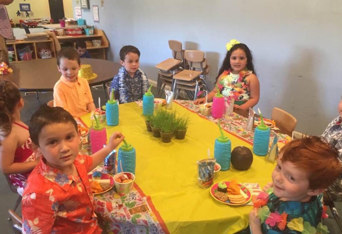 Children sitting around a table with drinks and plates