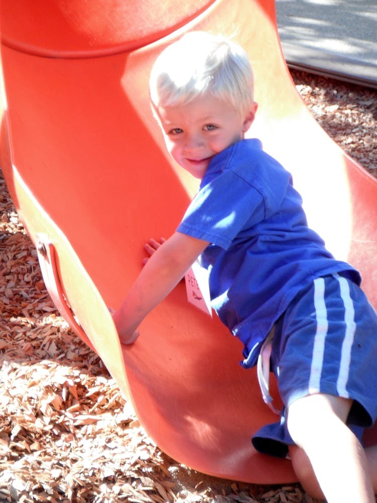Child on an orange playground slide