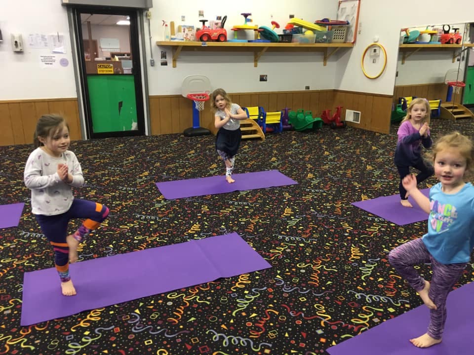 Children doing yoga poses on mats