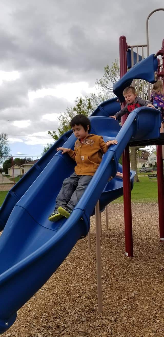 Child on a blue slide at a playground