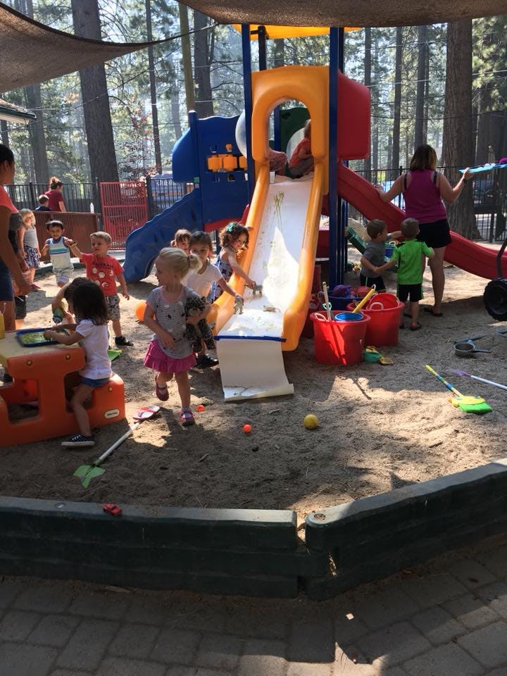 Children playing on a playground with slides and in a sandbox