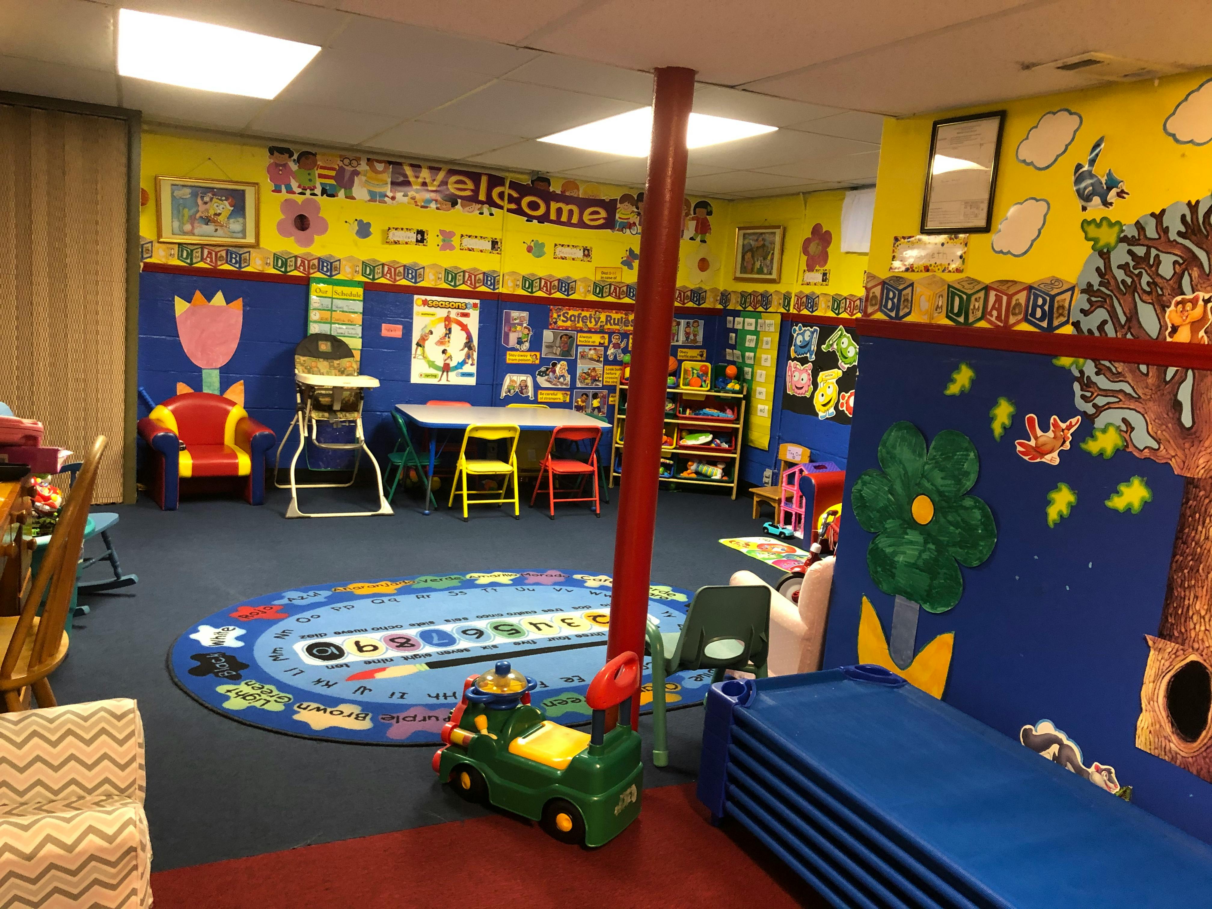Colorful classroom with small tables, chairs, and a rug