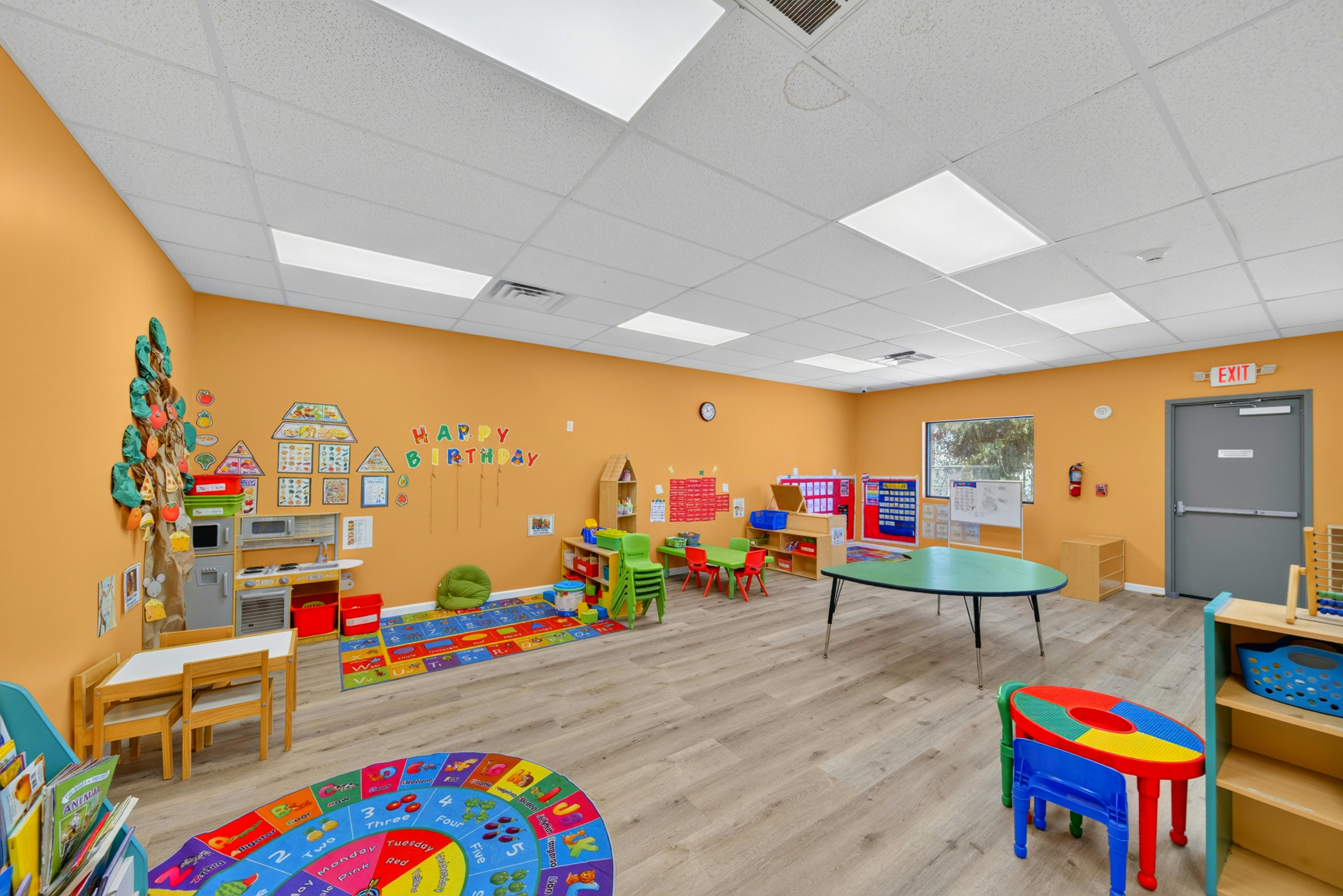 Empty preschool classroom with children furniture and educational wall decor