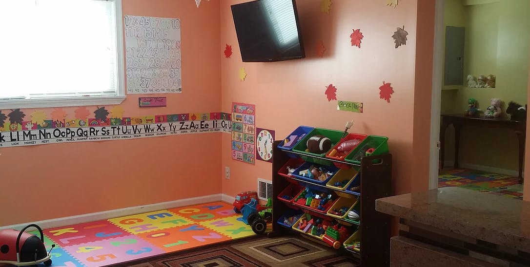 Playroom with alphabet border, colorful floor mats, and toy organizer
