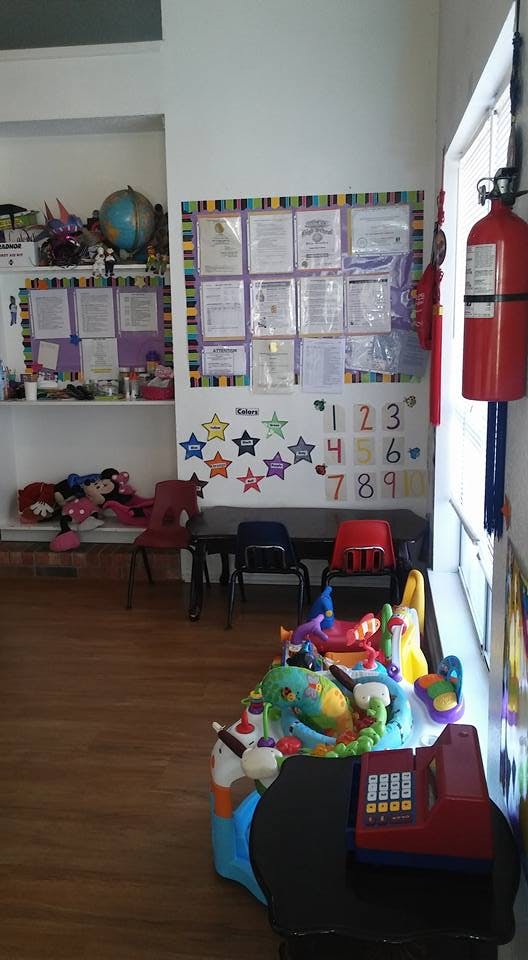 Classroom with children's tables and chairs, toys, and bulletin boards