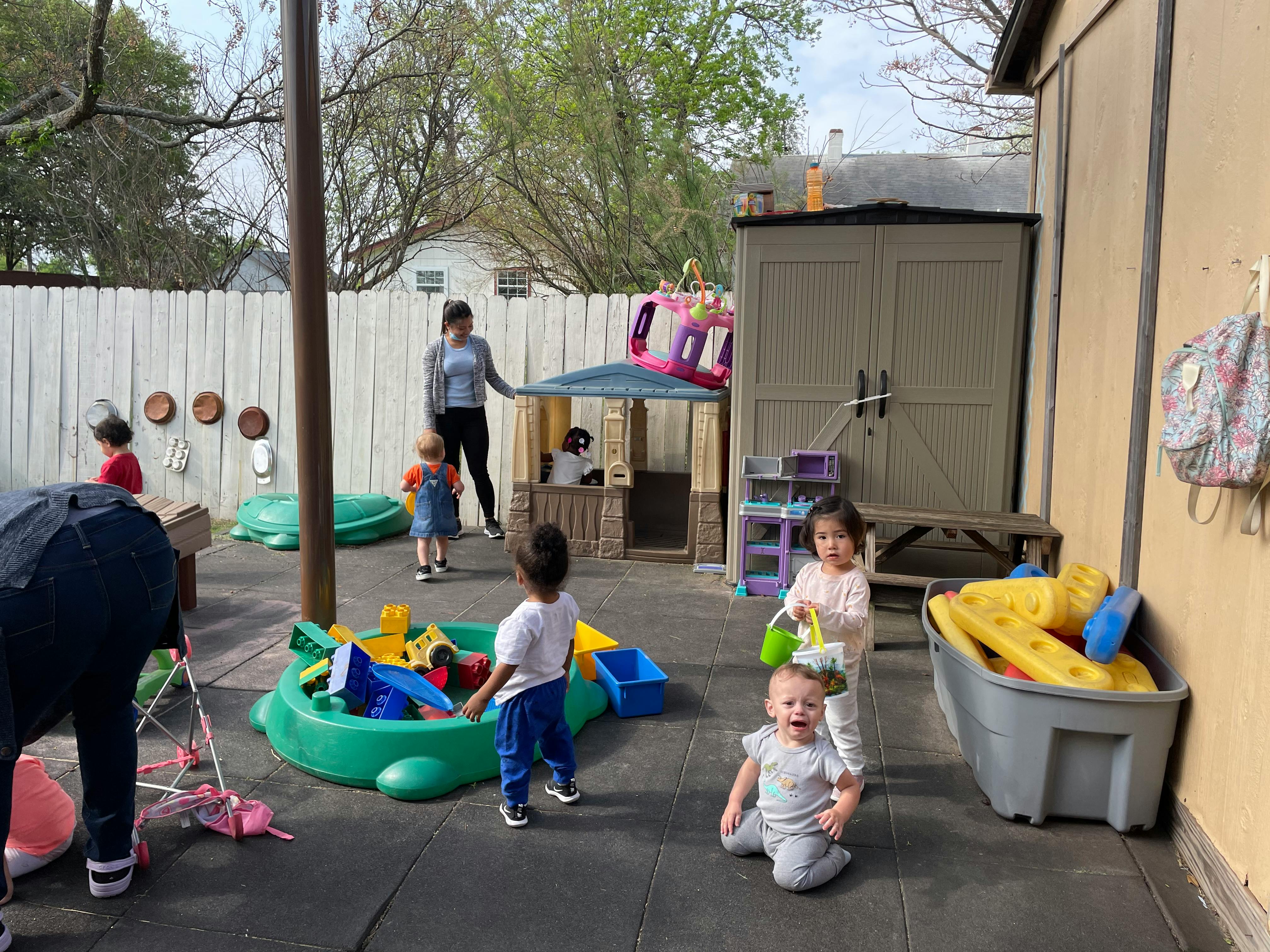 Adult and children playing outdoors with toys