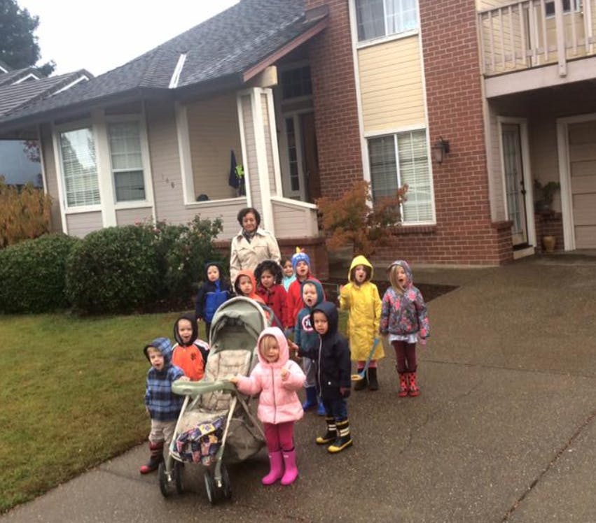 Person with a group of children and a stroller outdoors