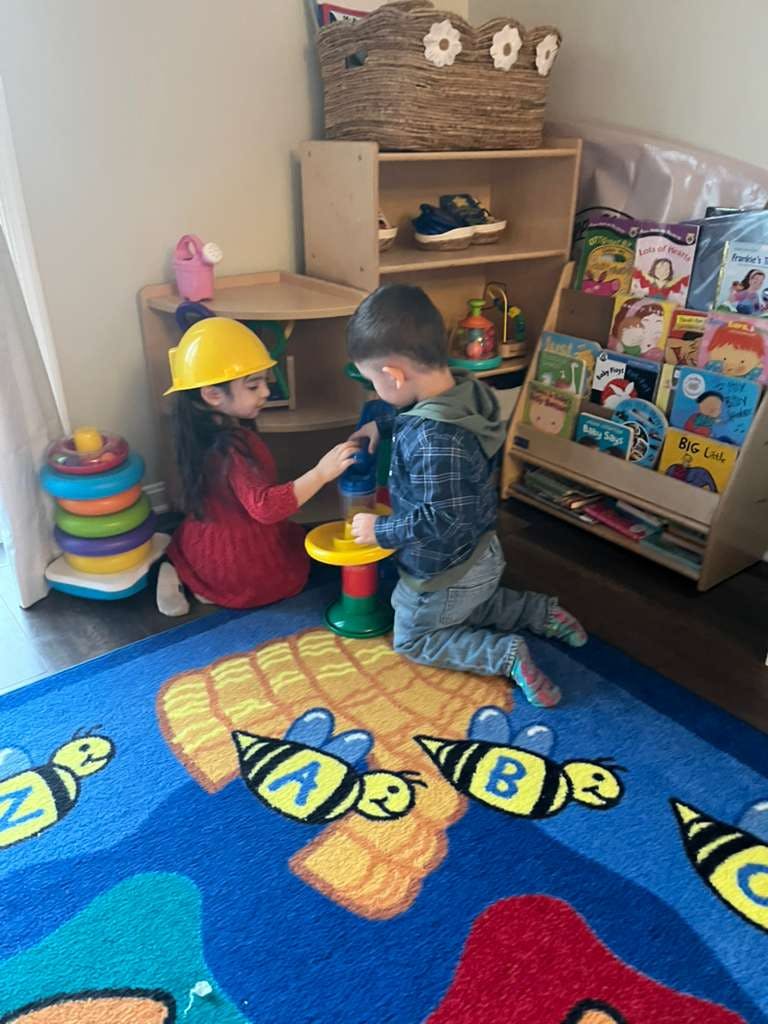 Two children playing with toys in a classroom