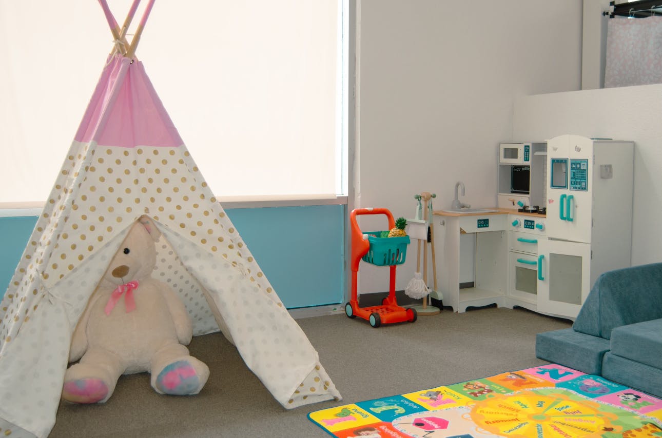 Playroom with teepee, stuffed animal, toy kitchen, and shopping cart