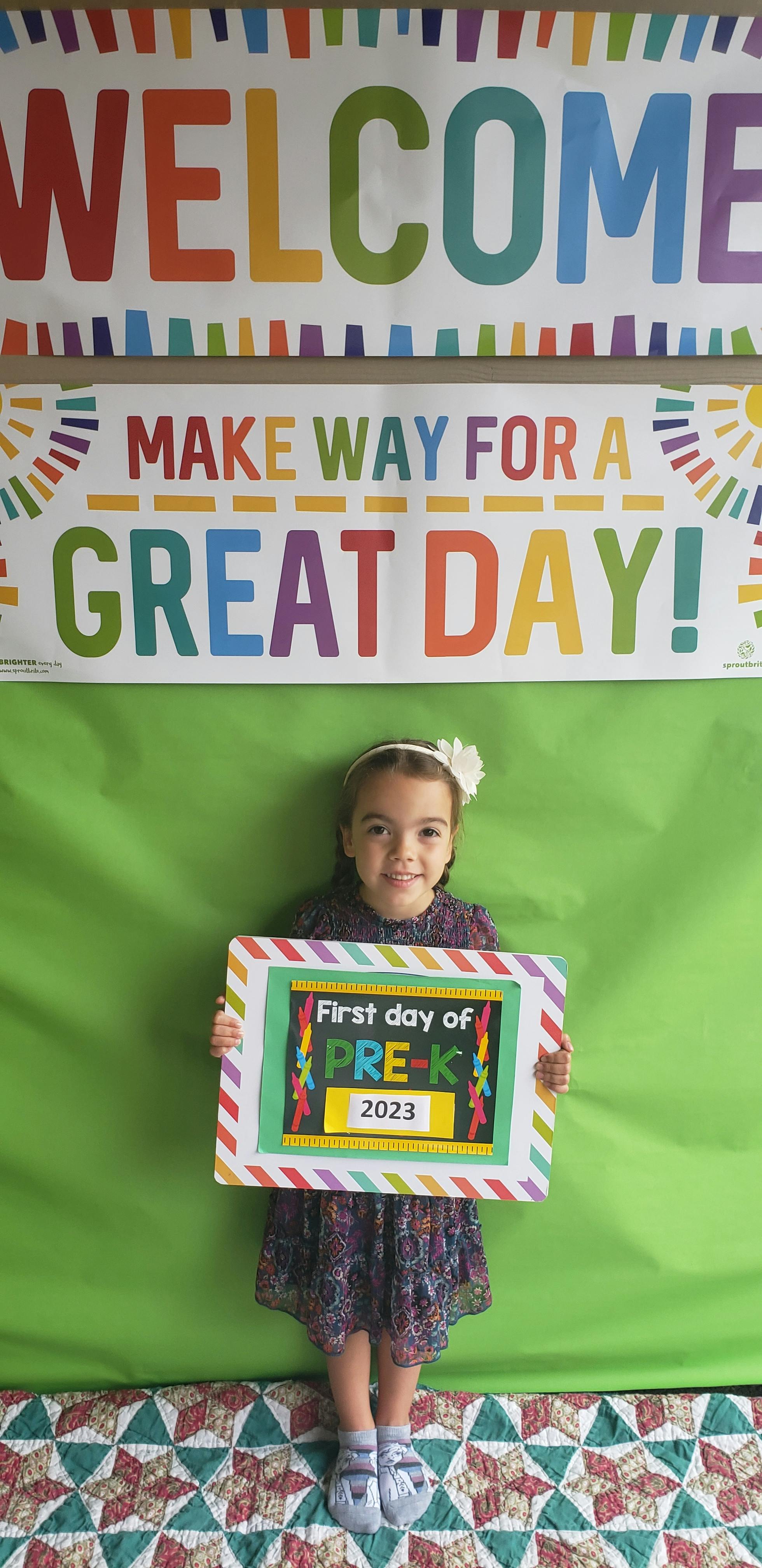Child holding a sign that reads "First day of PRE-K 2023"