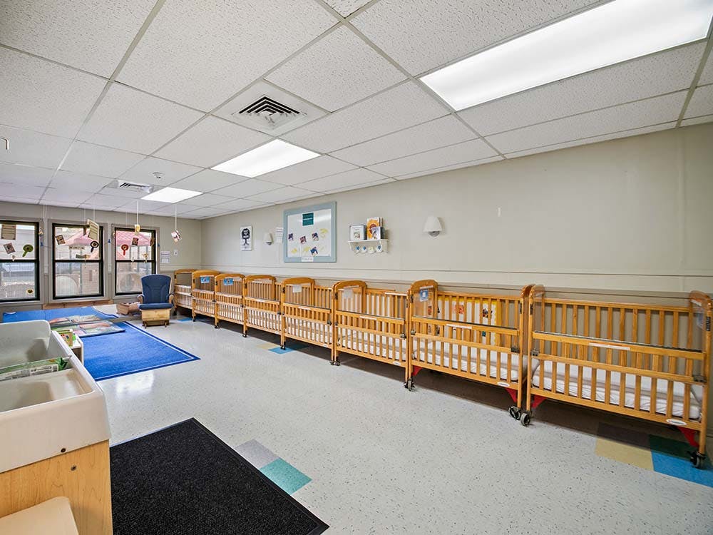 Cribs in a row in a daycare classroom