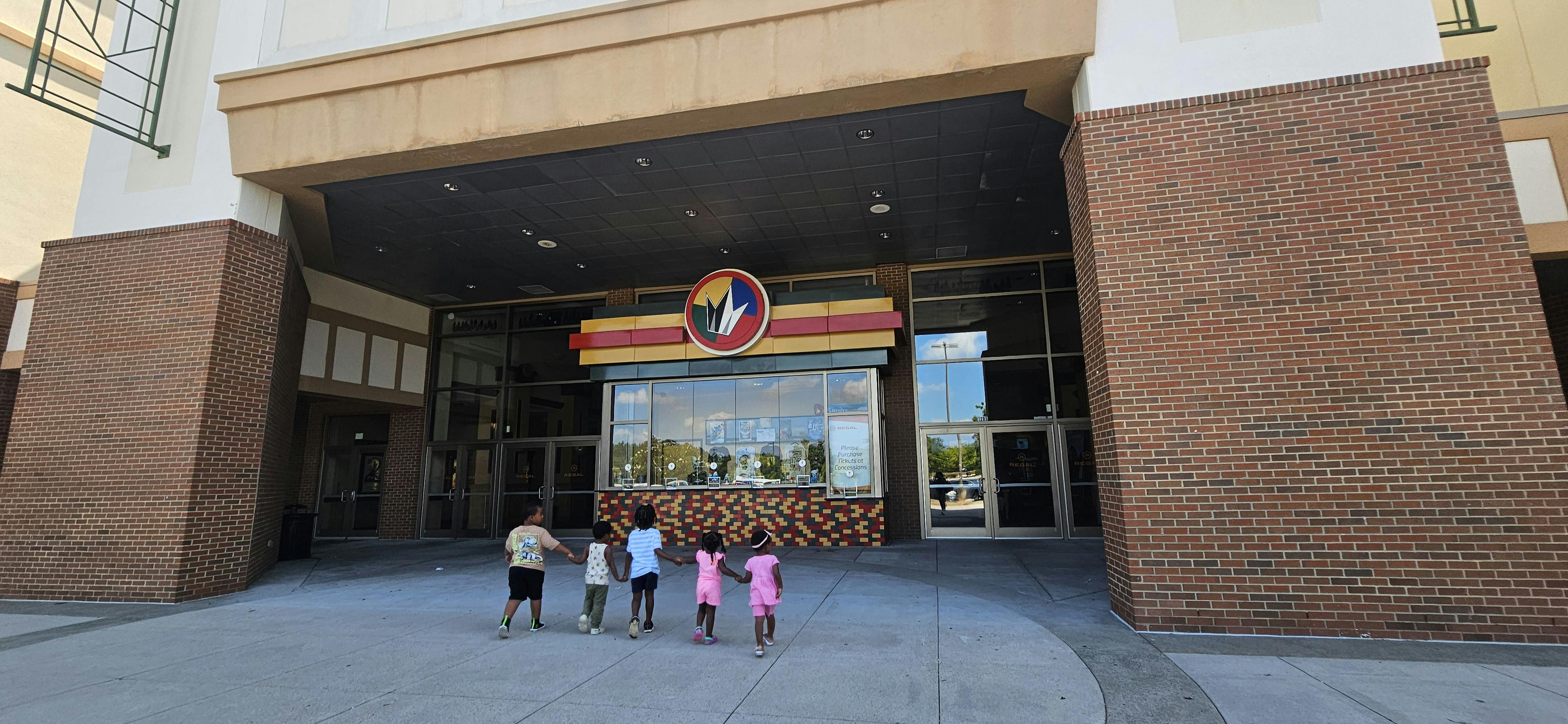Four children standing in front of a building entrance