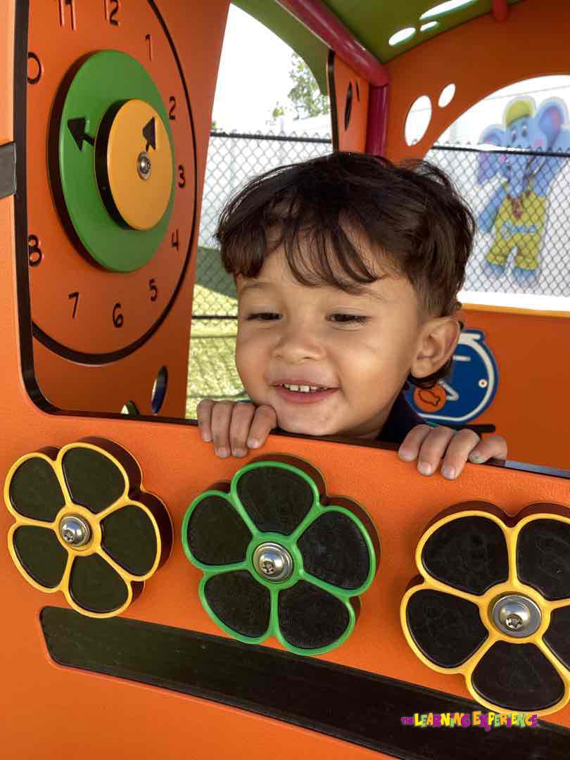 Child looking over a colorful play structure