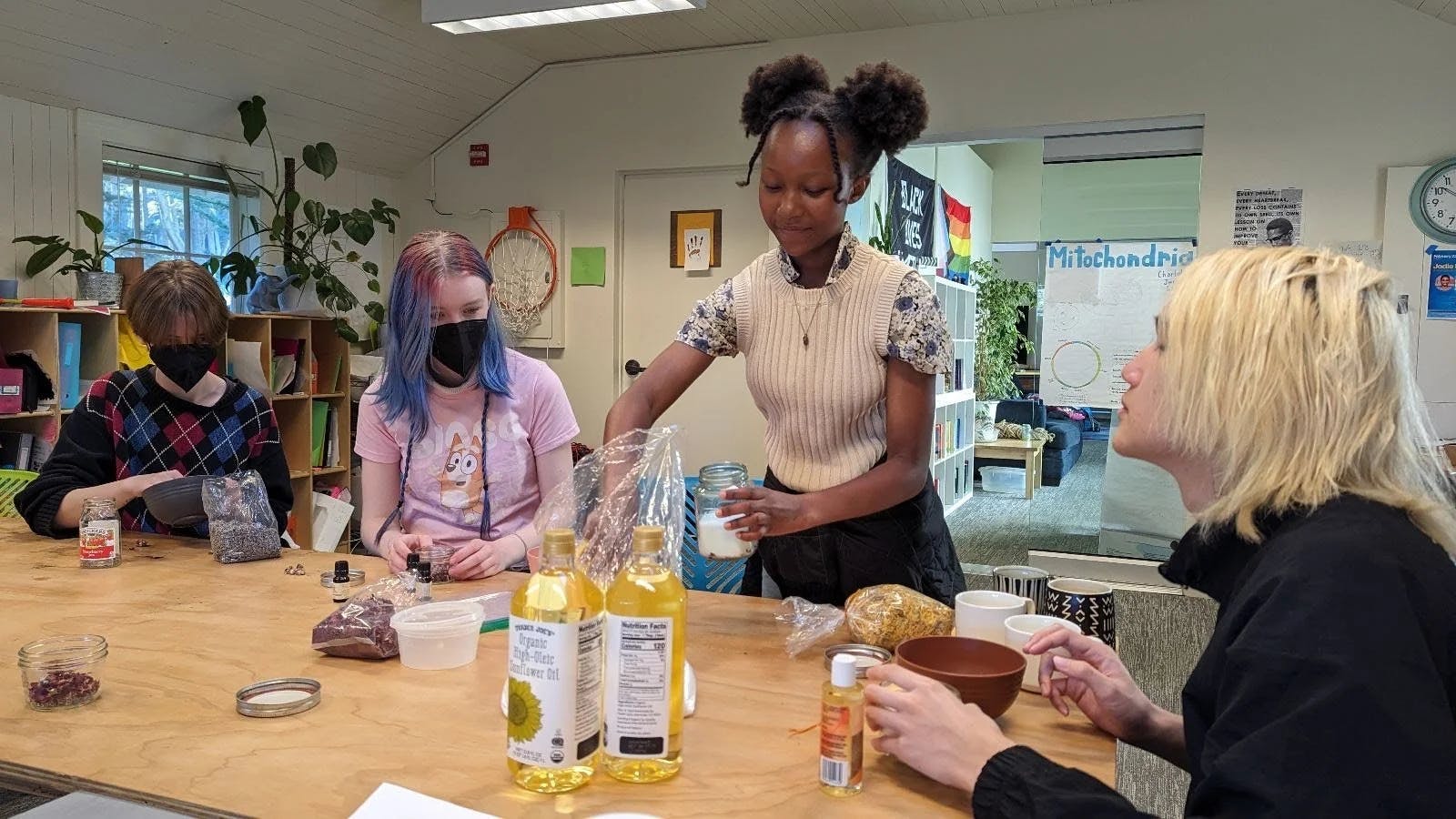 People making products with oils and other ingredients on a wooden table