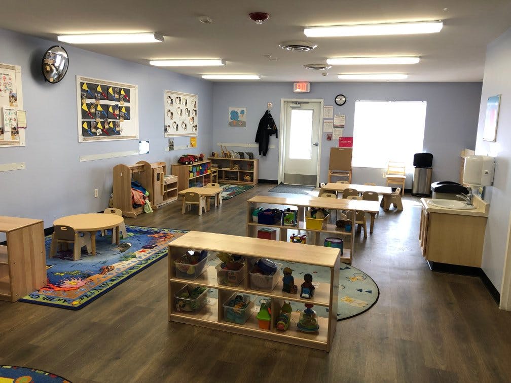 Classroom with small tables and chairs, toys, and learning materials