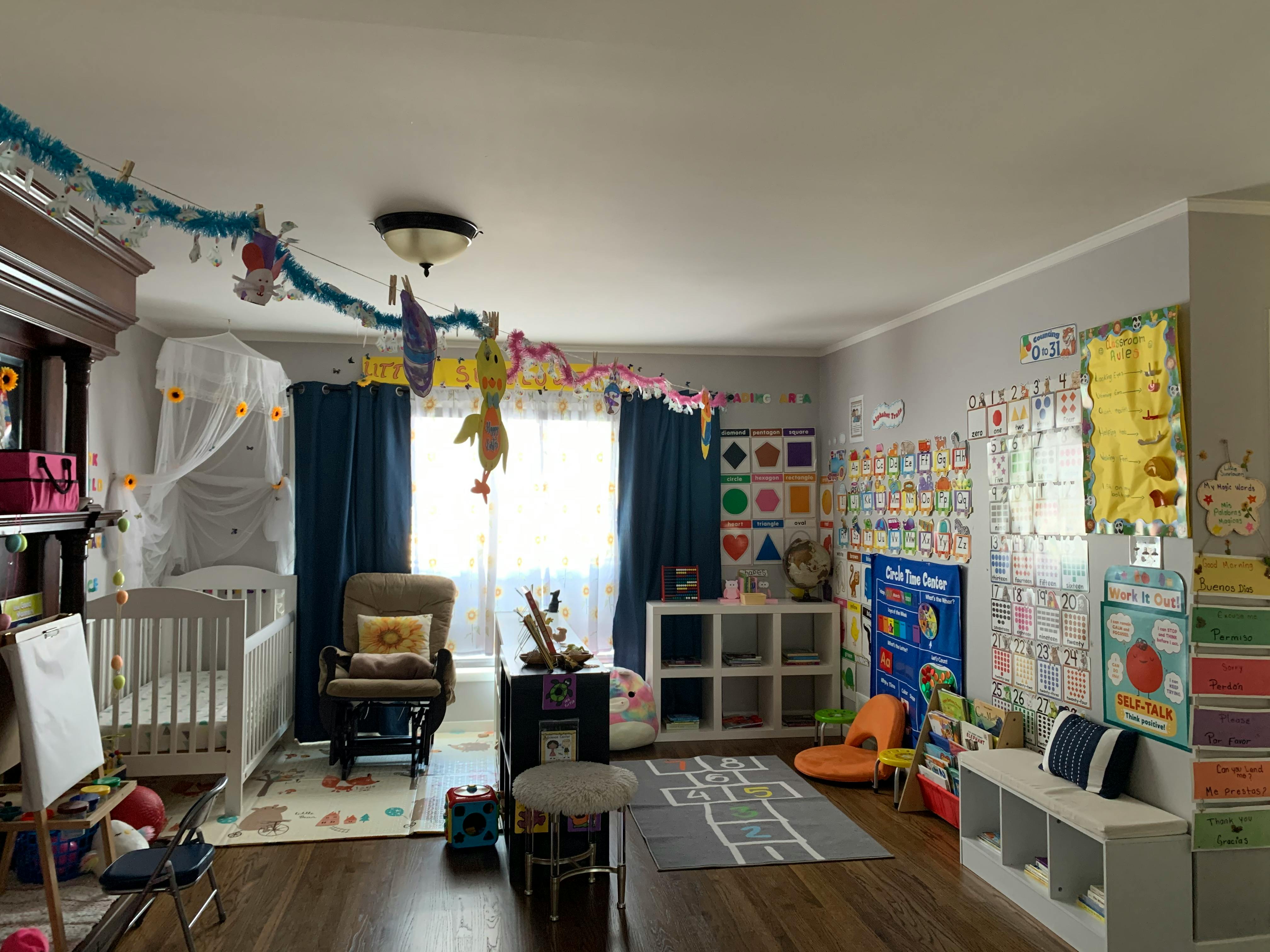 Child's room with a crib, rocking chair, and educational posters on the wall