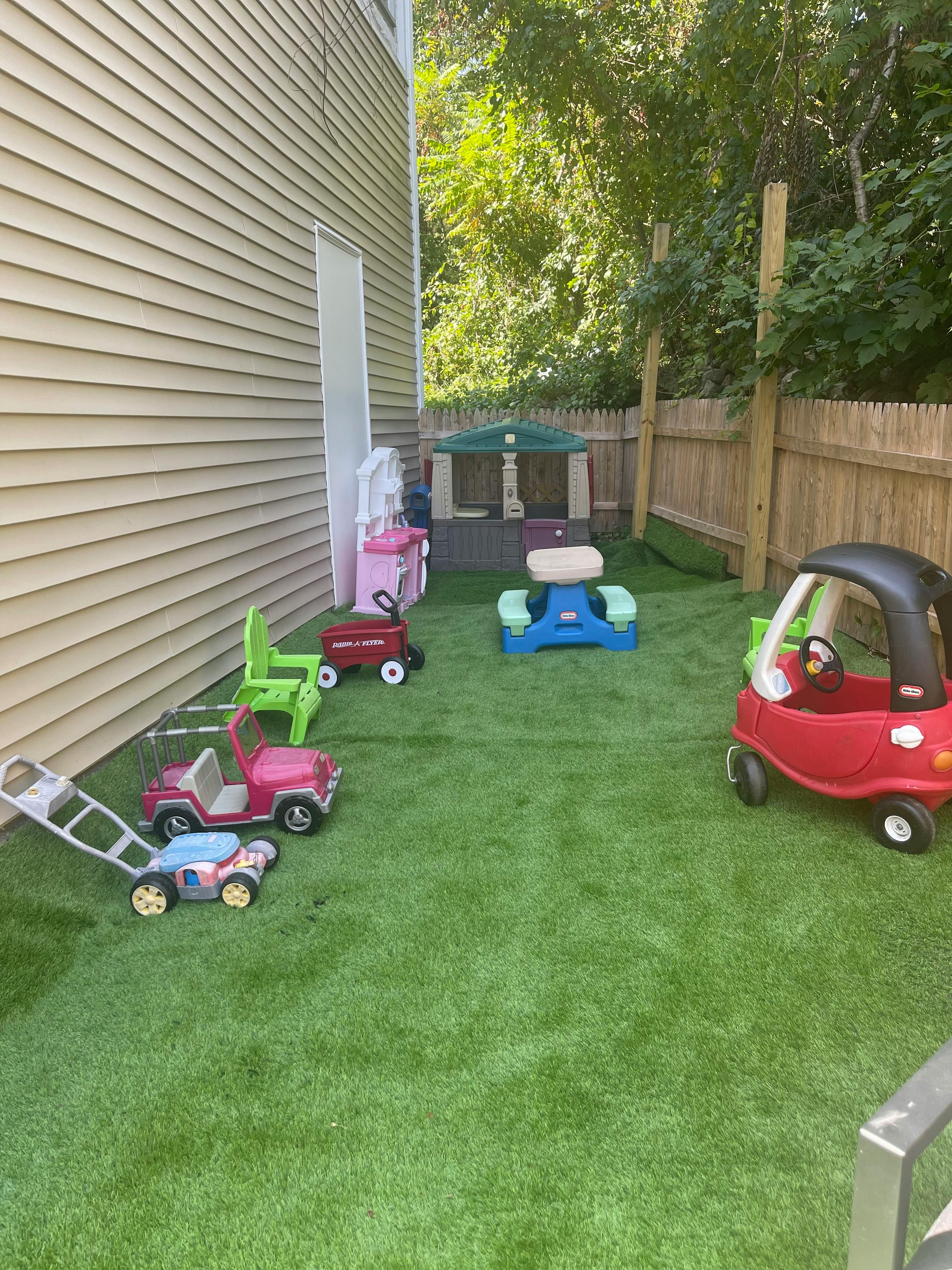Children's ride-on toys and playhouse on artificial grass