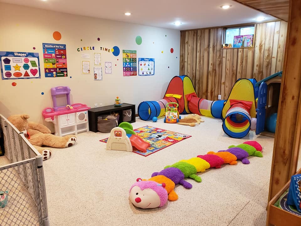 Indoor play area with colorful tunnels, toys, and a large stuffed caterpillar