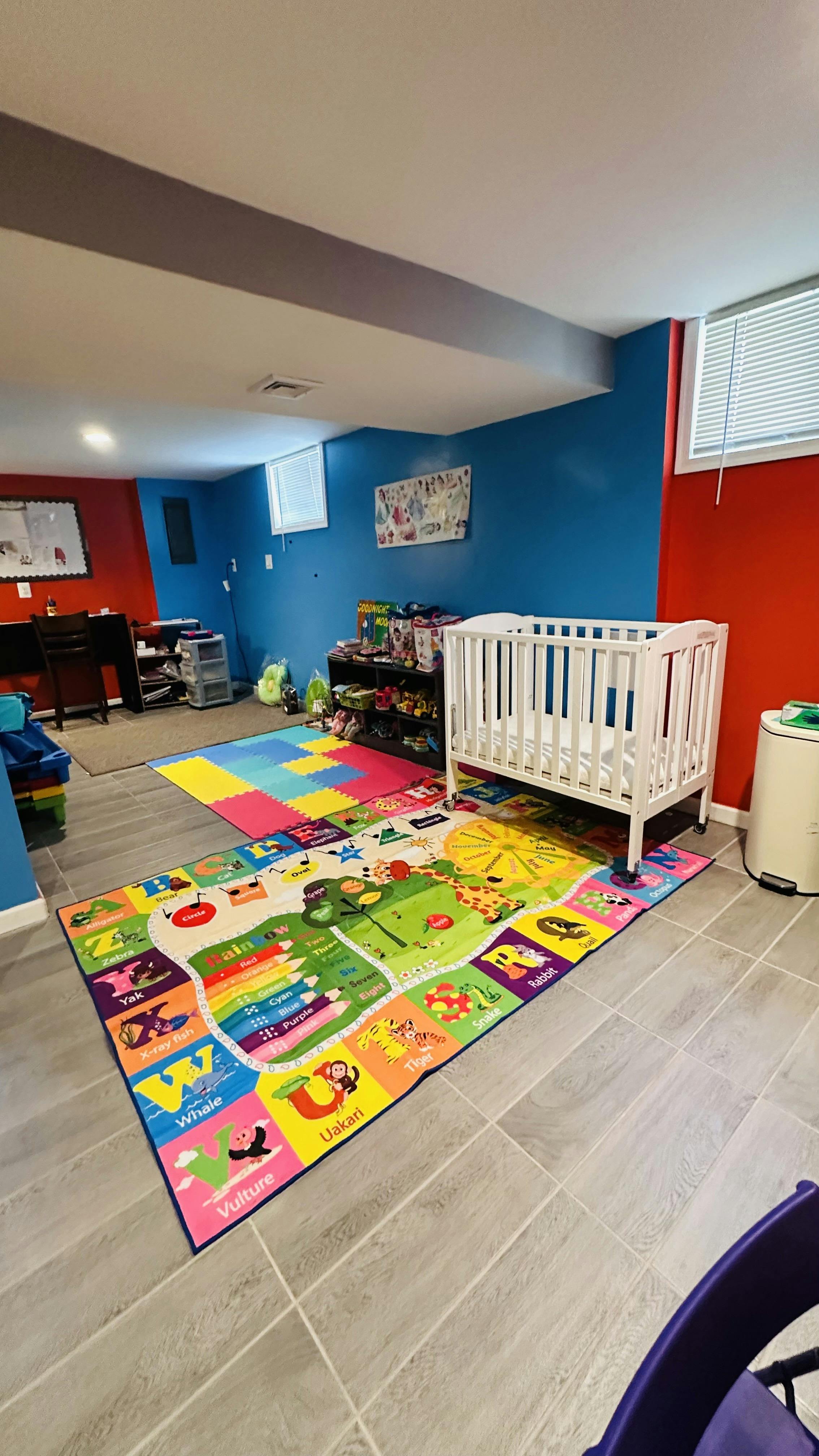 crib and colorful learning rugs on a tiled floor in a child's play area