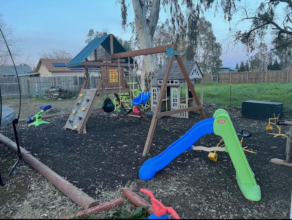 Outdoor playground with swings, slides, and a climbing wall