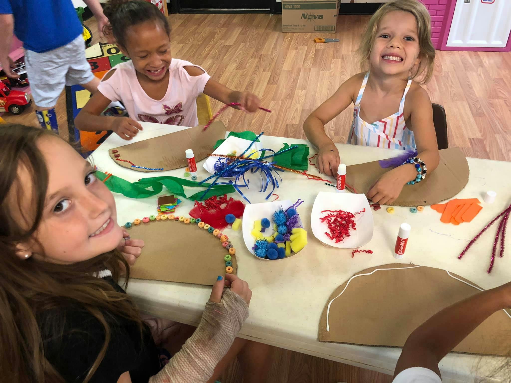 Three children doing crafts at a table