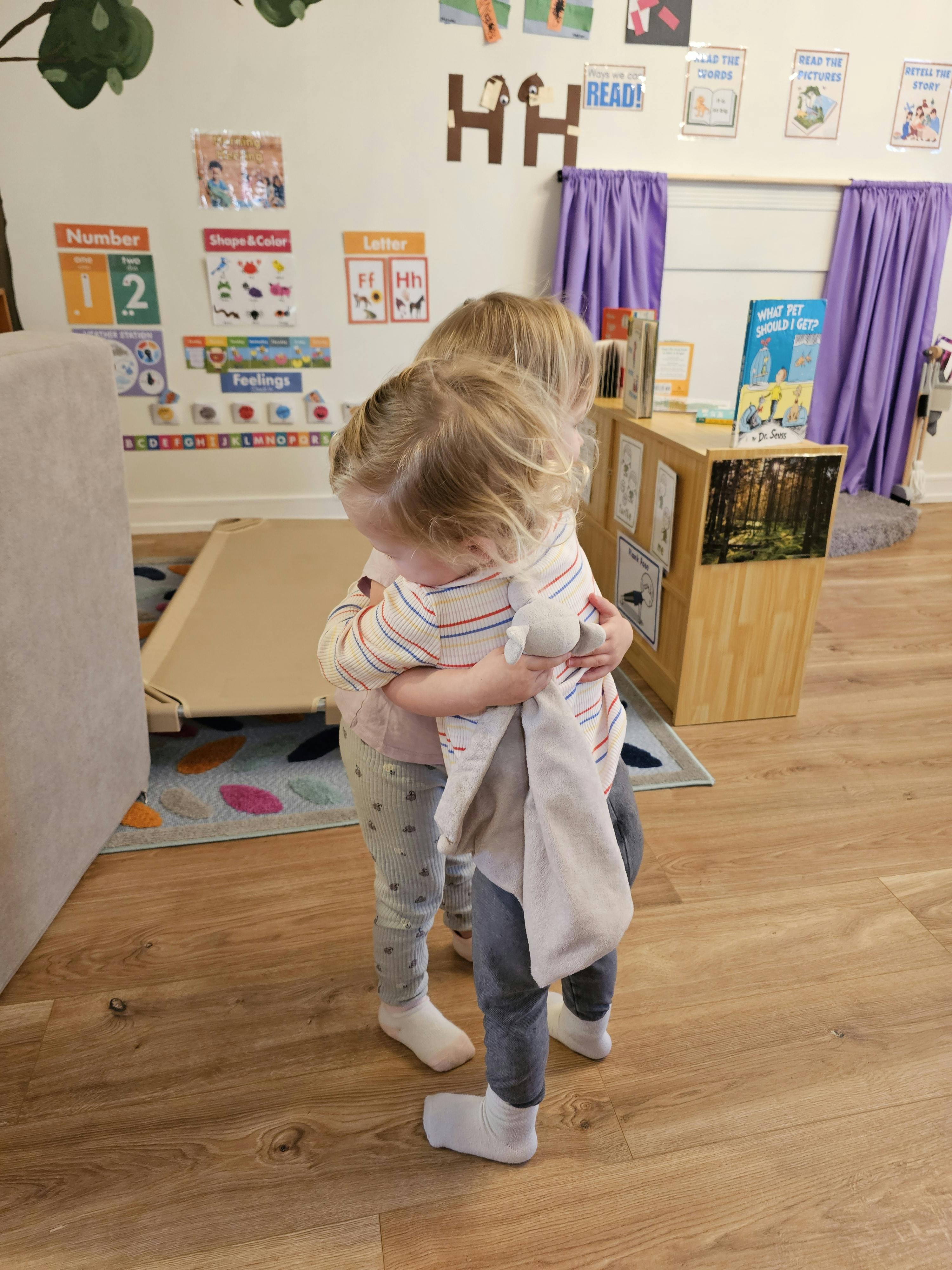 Two children hugging in a classroom