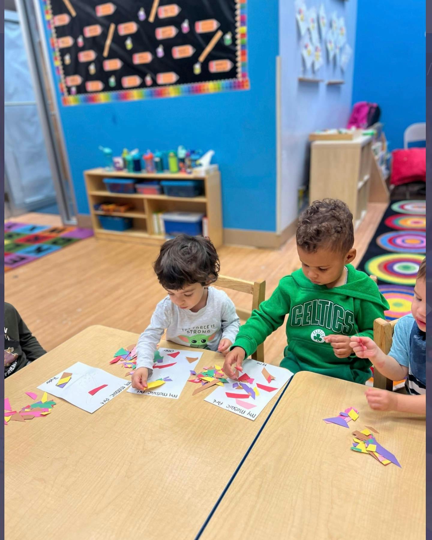 Children doing crafts at a table in a classroom