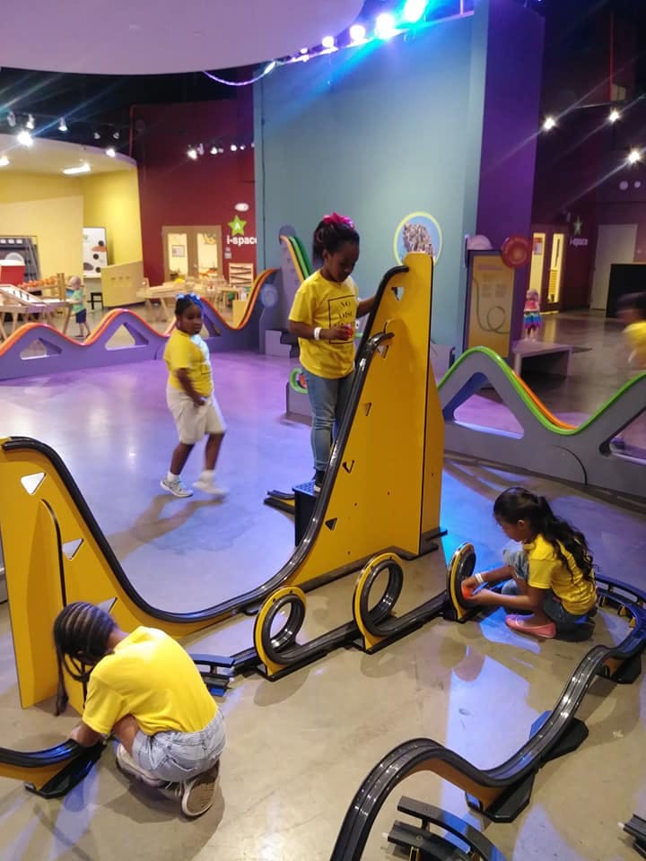 Children playing with a large toy car track