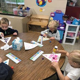 Three children doing crafts at a table