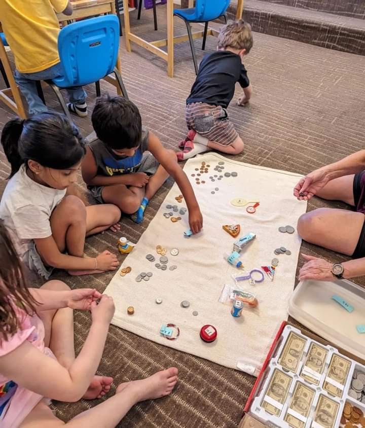 Children playing with small objects on a blanket on the floor