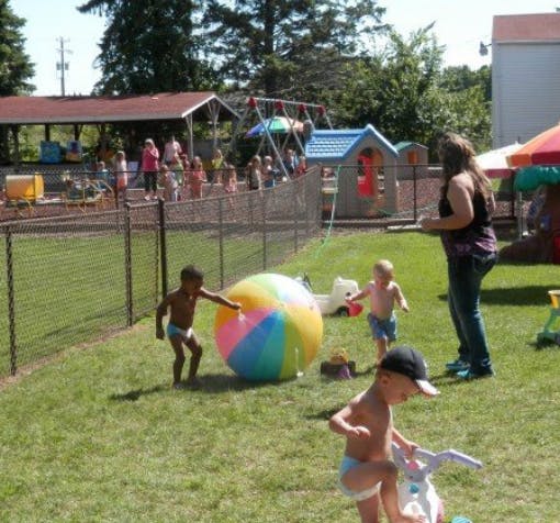 Children playing with a large beach ball in a grassy area