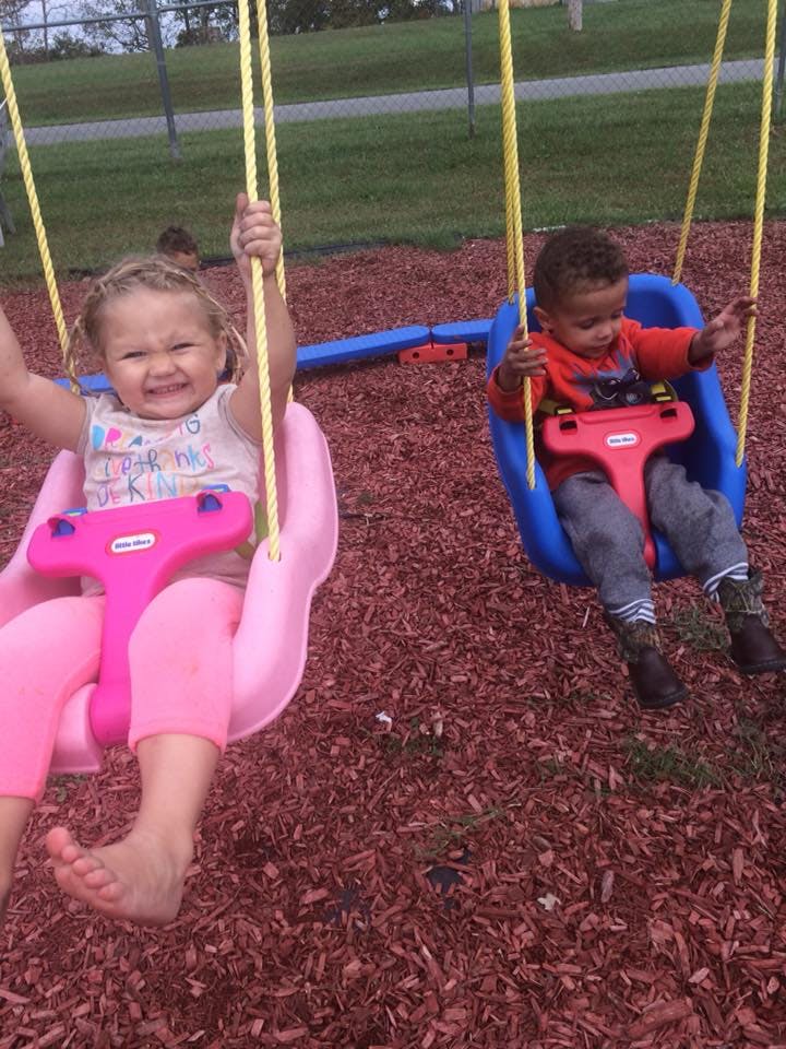 Two children on swings at a playground