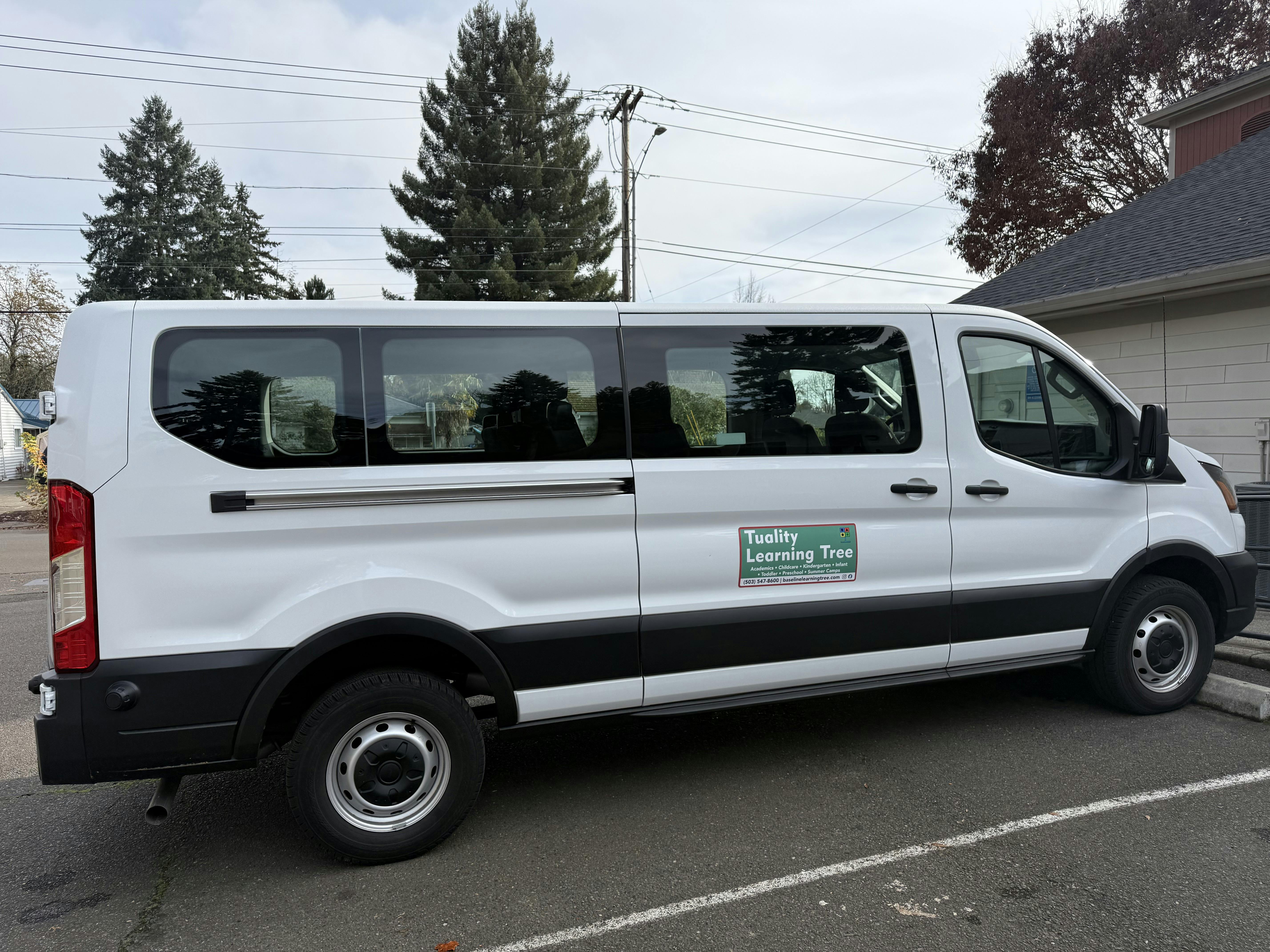 White passenger van with a green sign on the side